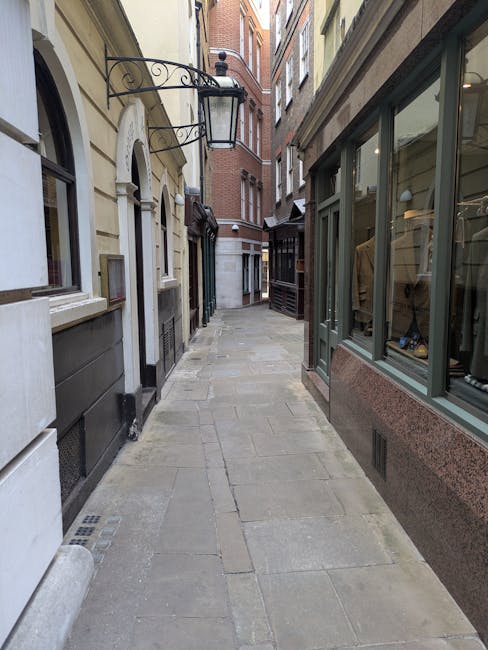 The image depicts a historic multi-storey brick residential building on Sloane Street in Belgravia, featuring ornate architectural details including arched windows, decorative brickwork, and small bal